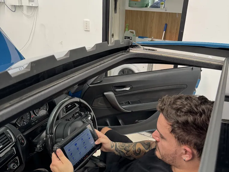 Checkpoint Motors technician running a diagnostic scan inside a customer car